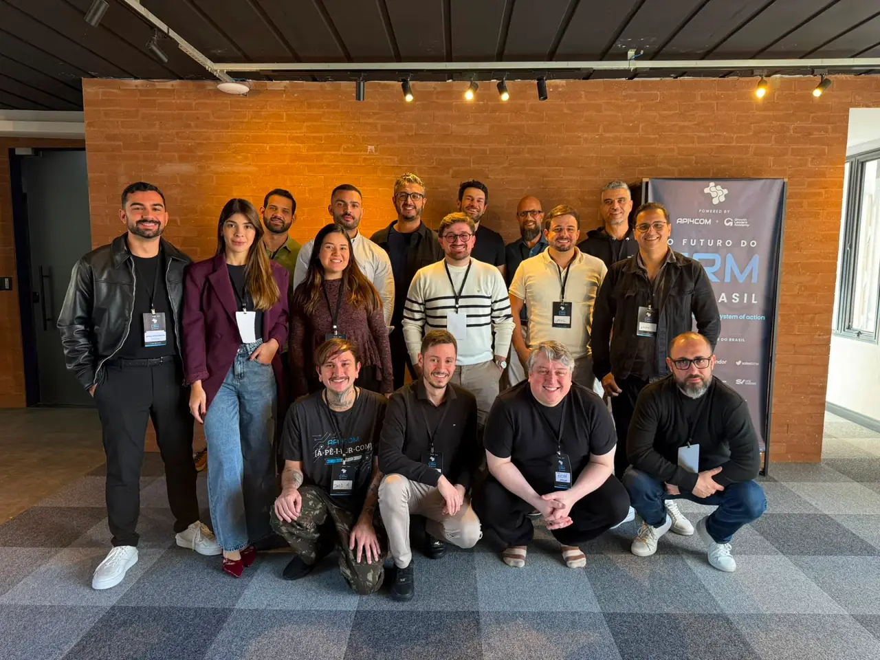 Foto do grupo de participantes do evento O Futuro do CRM no Brasil, diante do banner, em São Paulo